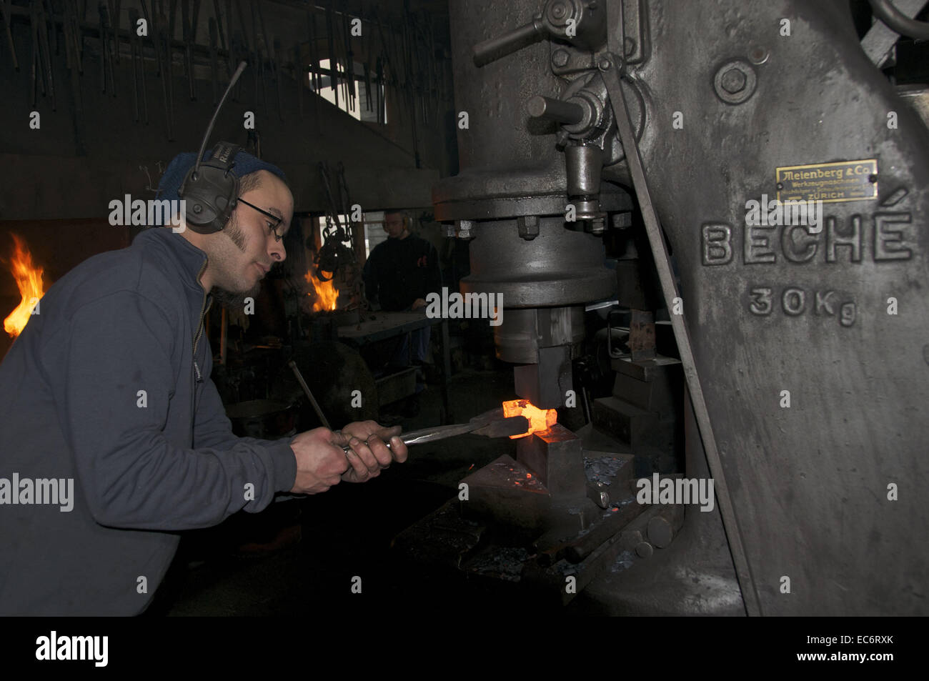 blacksmith working the steamhammer on redhot steel Stock Photo