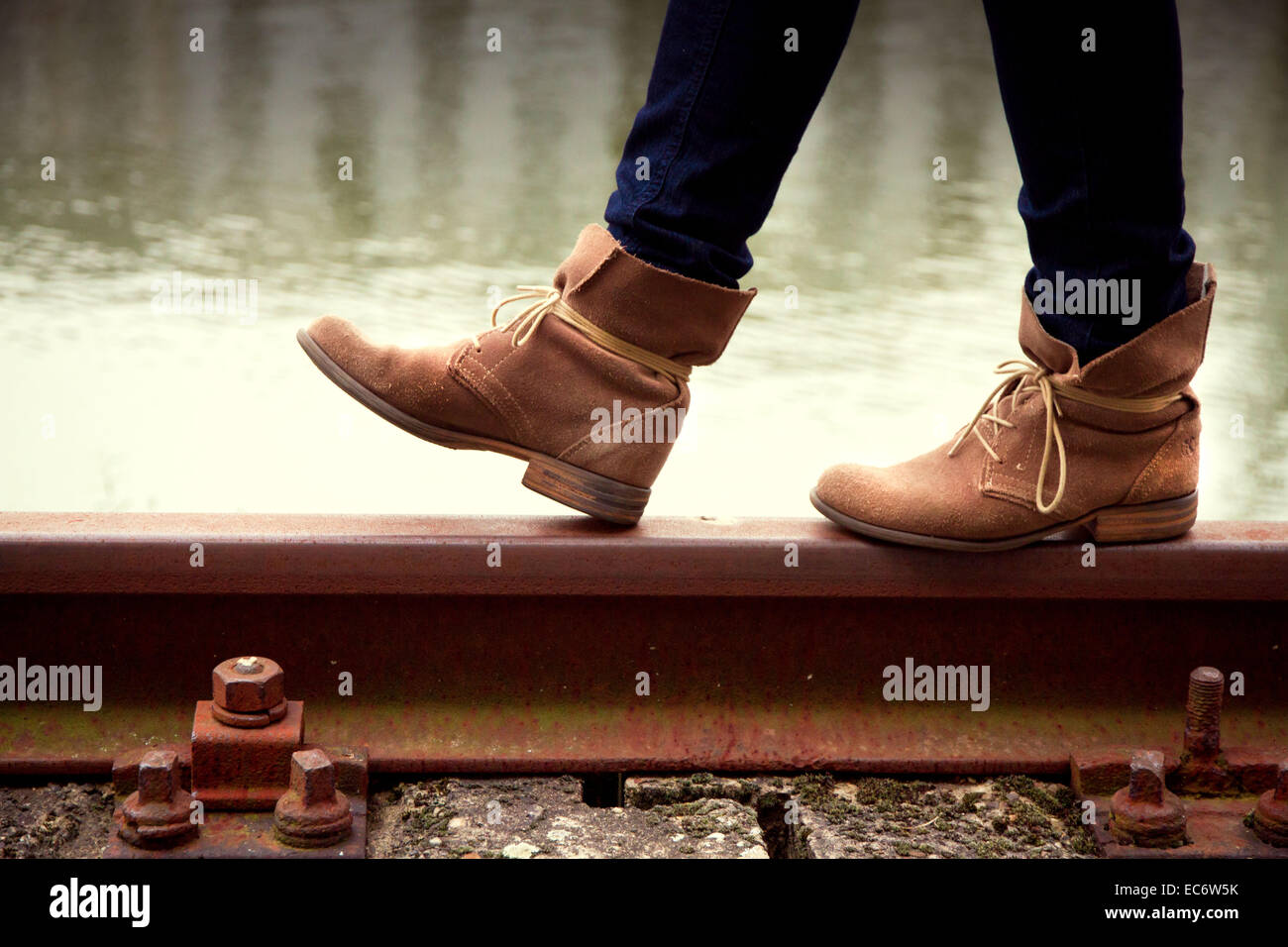 Young woman balancing on railway track Stock Photo - Alamy