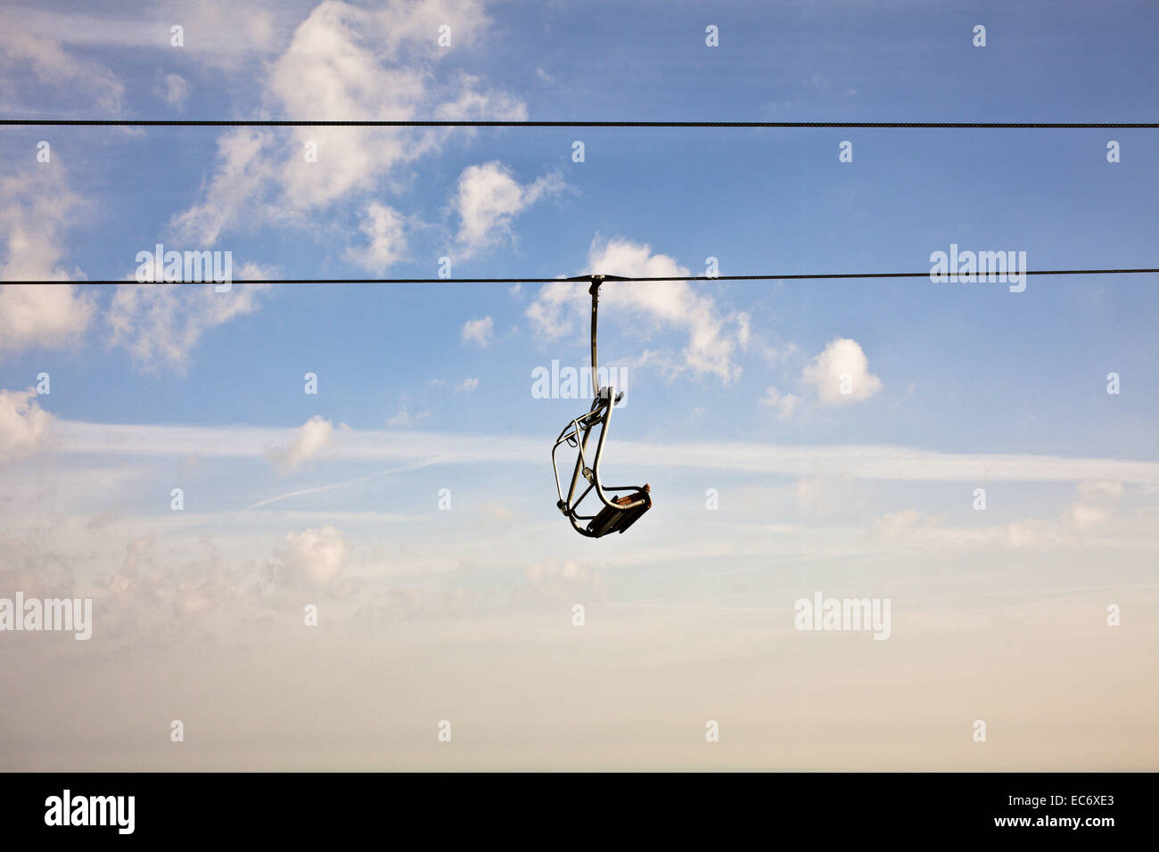 An emty seat of a lift infront of the sky.Synonym for freedom and lonelyness at the same time. Stock Photo