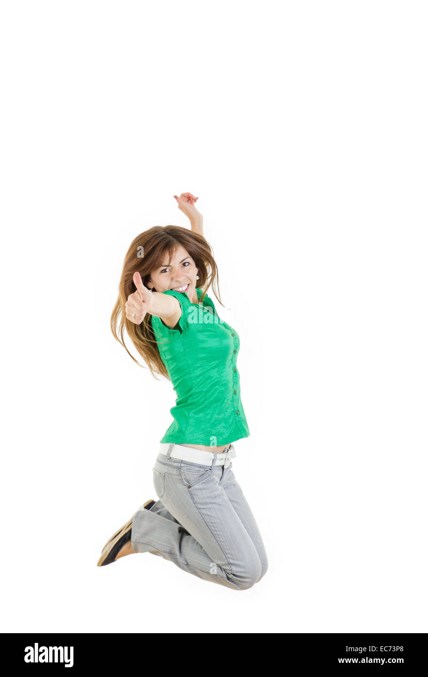 Pretty woman or girl jumping  with thumb up of joy excited isolated on white background in green shirt and gray jeans ,  casual  Stock Photo