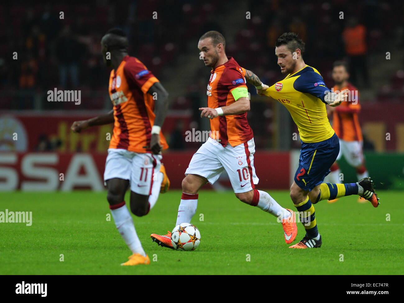 Istanbul, Turkey. 9th Dec, 2014. Galatasaray's Wesley Sneijder (2nd L) pulls the jersey of Arsenal's Mathieu Debuchy (1st R) during the UEFA Champions League group D football match at Ali Sami Yen Stadium in Istanbul, Turkey, on Dec. 9, 2014. Arsenal won 4-1. © Lu Zhe/Xinhua/Alamy Live News Stock Photo