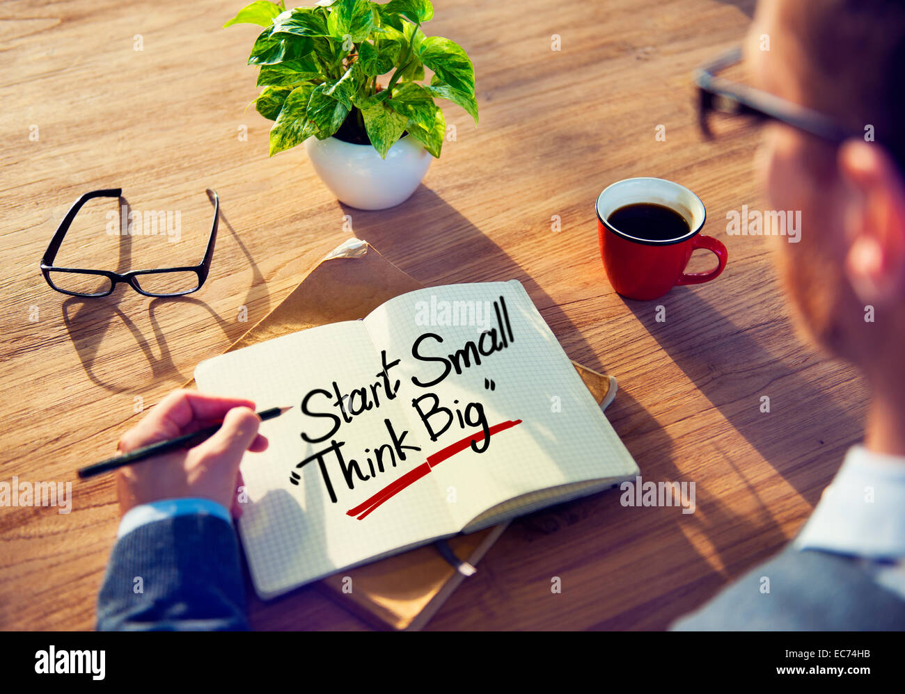 Man with a Note and a Word Start Small Think Big Stock Photo