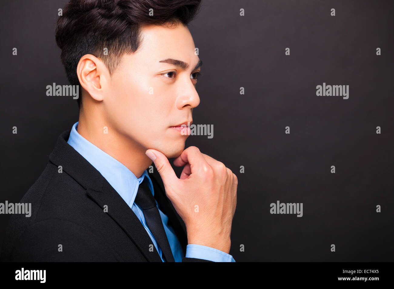 side view Smiling businessman standing on black background Stock Photo