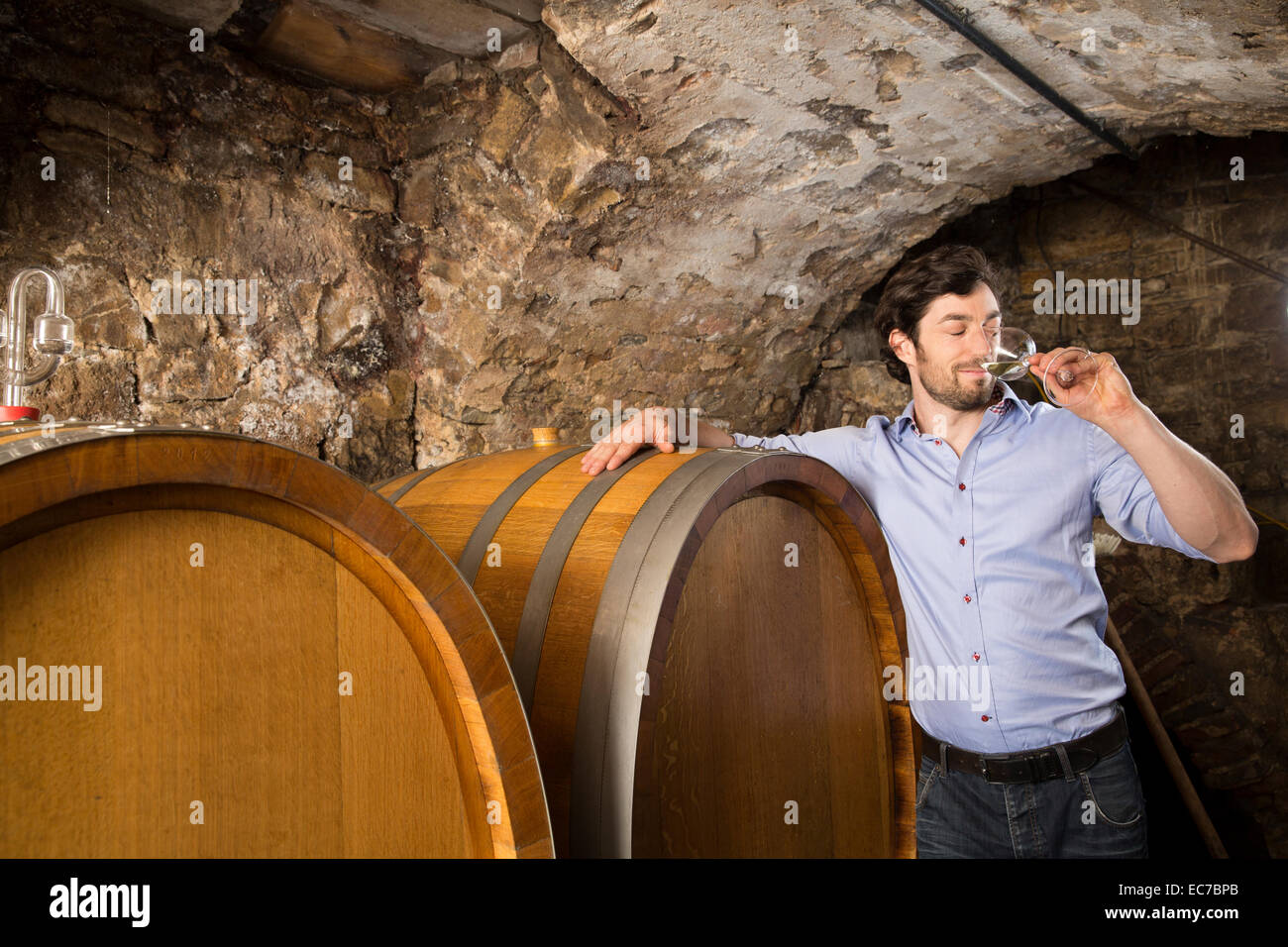 Man in wine cellar tasting wine Stock Photo - Alamy