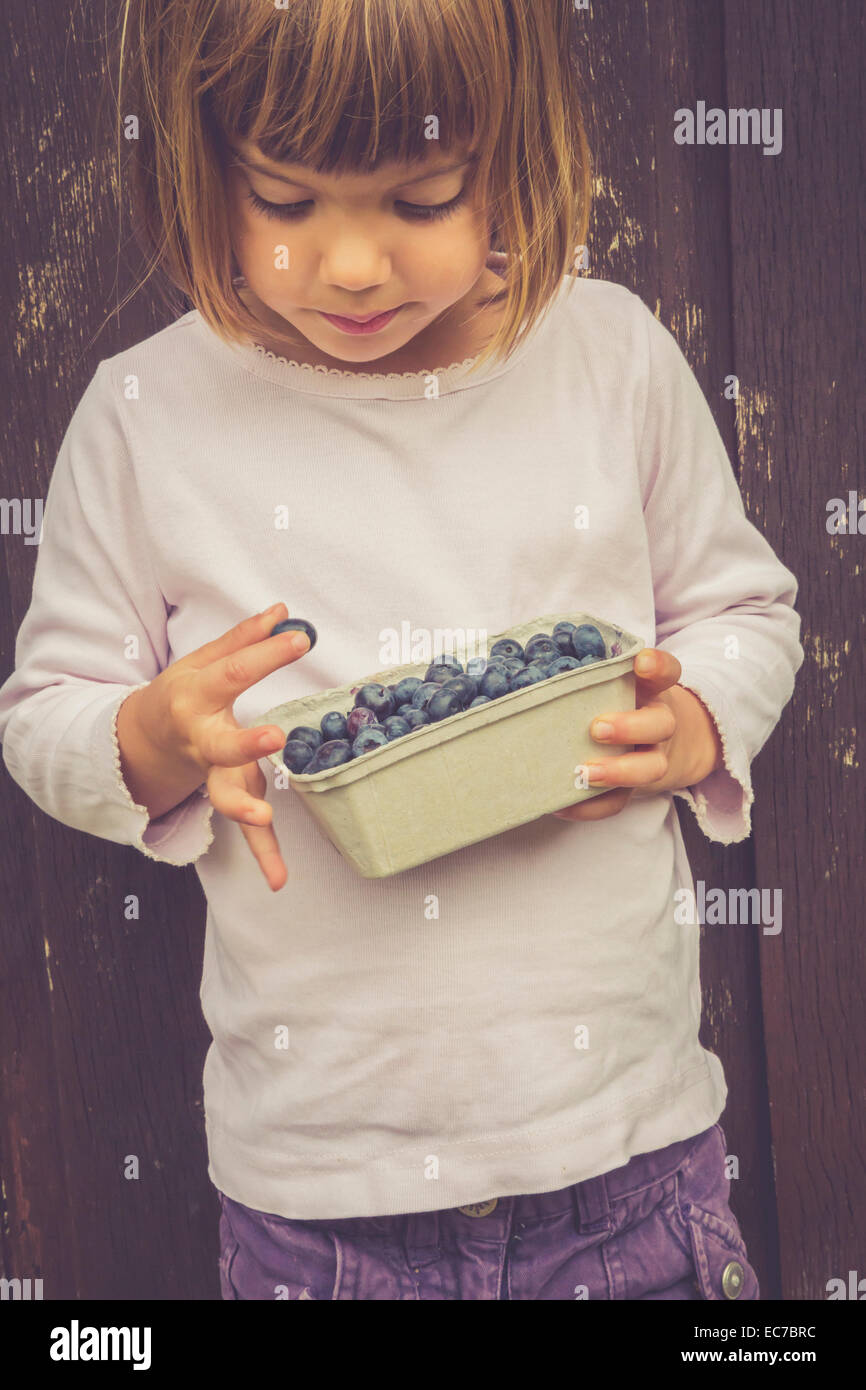 Little girl with box of blueberries Stock Photo Alamy