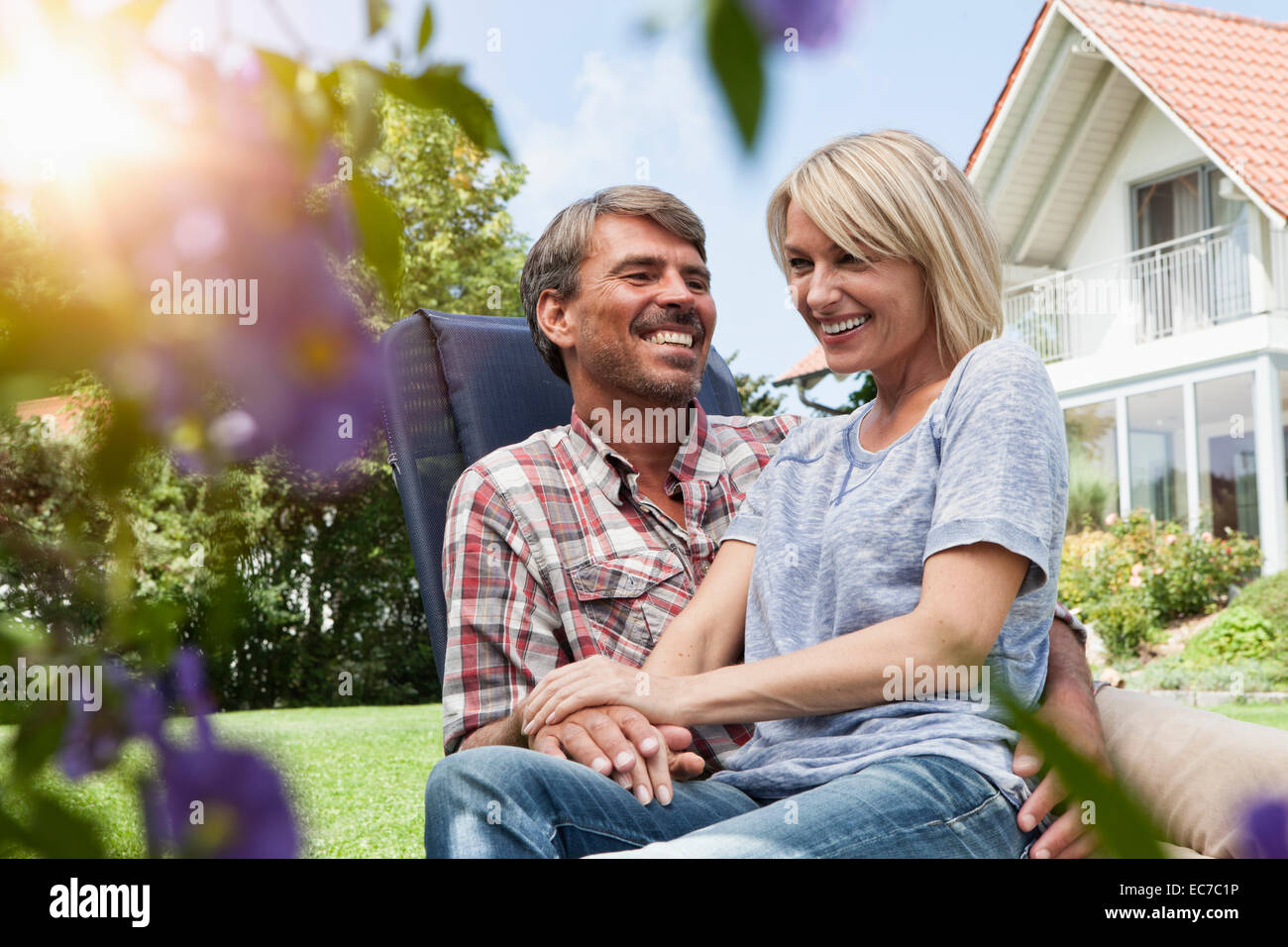 Happy mature couple on deck chair in garden Stock Photo