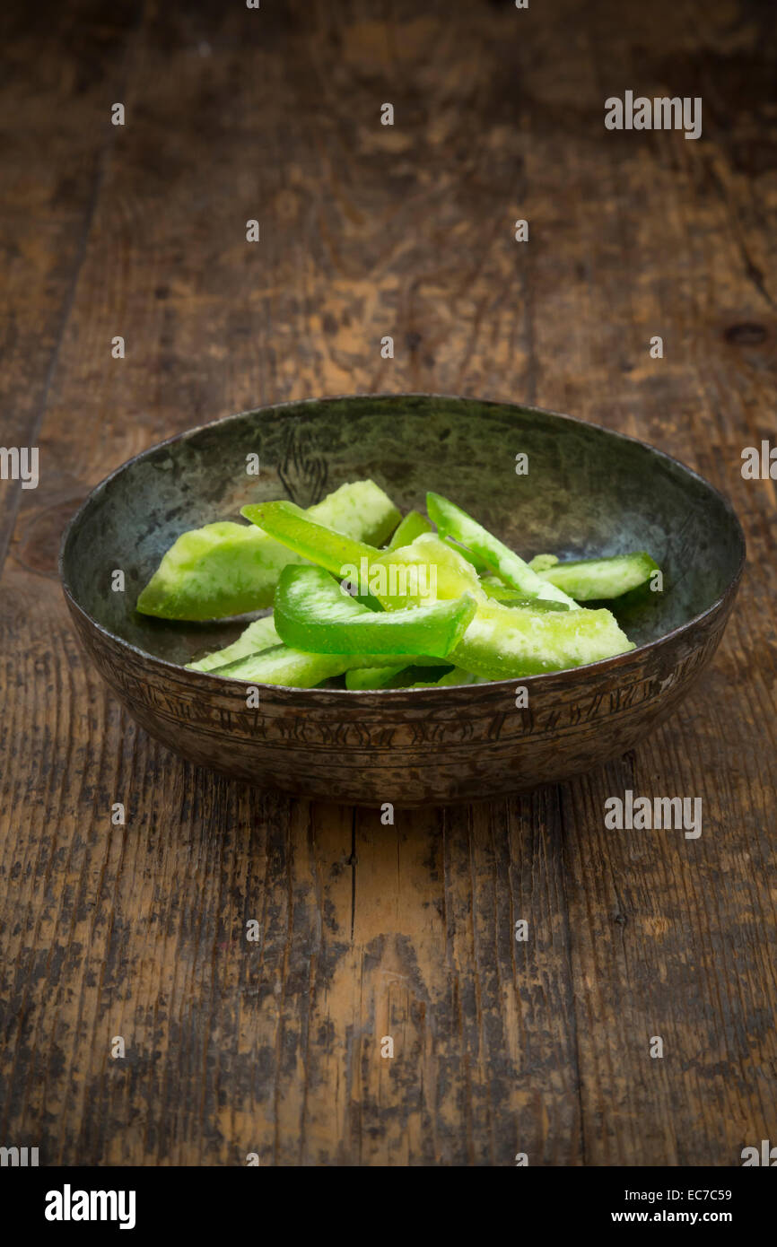 Bowl with dried unripe citron slices, Citrus medica, on dark wood Stock Photo