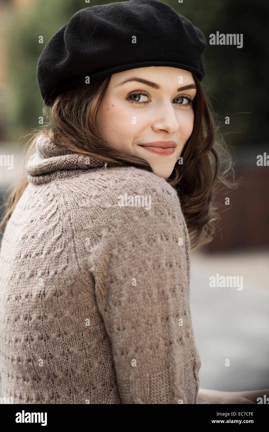 Portrait of smiling young woman wearing beret and knitted dress Stock ...