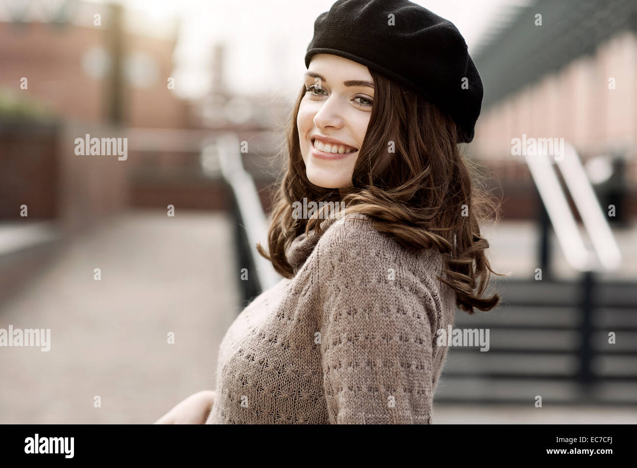 Portrait of smiling young woman wearing beret and knitted dress Stock ...