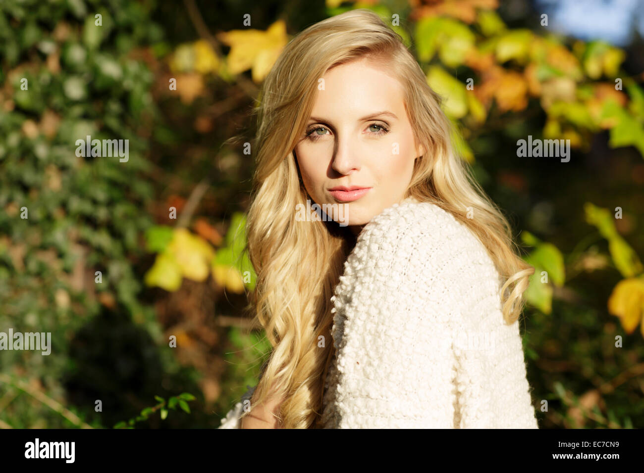 Portrait of blond woman in front of autumn leaves Stock Photo - Alamy