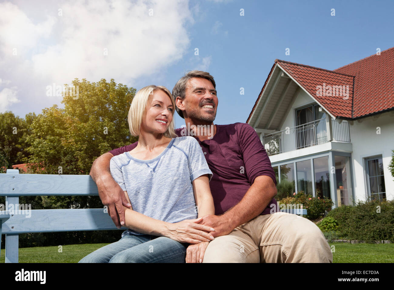Relaxed mature couple sitting on bench in garden Stock Photo - Alamy