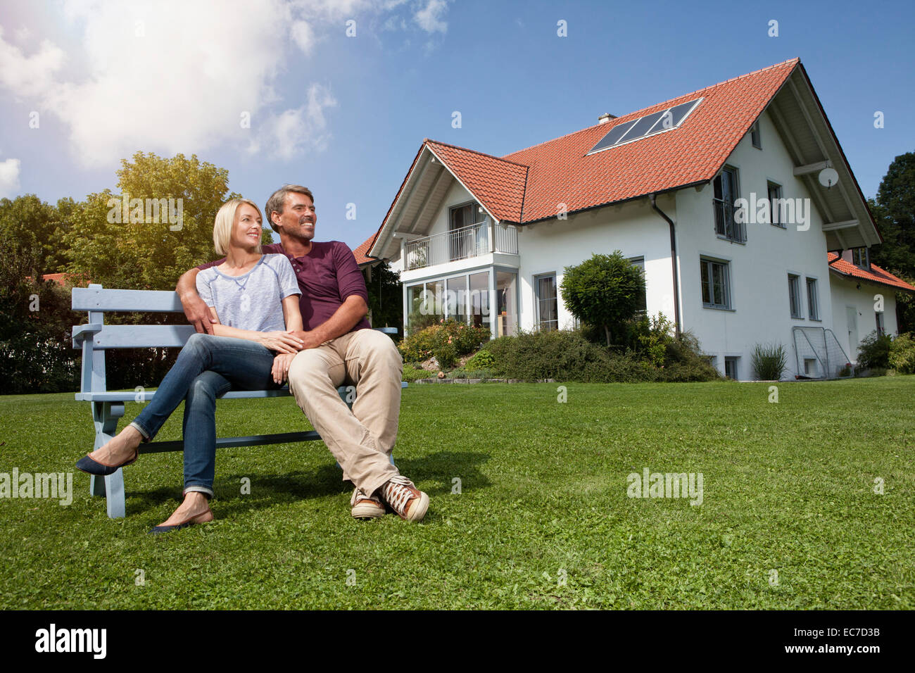 Relaxed mature couple sitting on bench in garden Stock Photo - Alamy