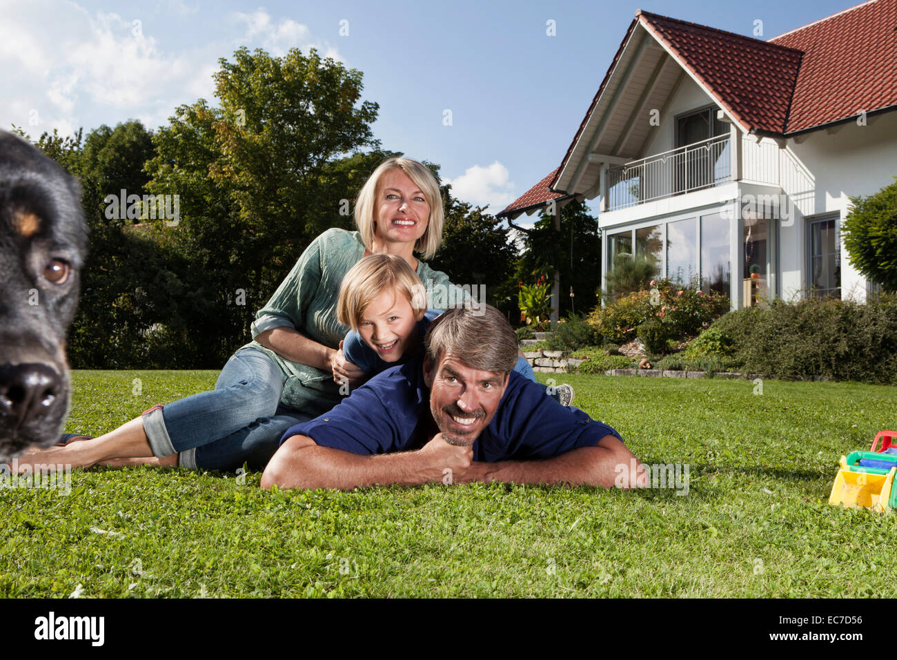 Happy family lying on lawn in garden Stock Photo - Alamy