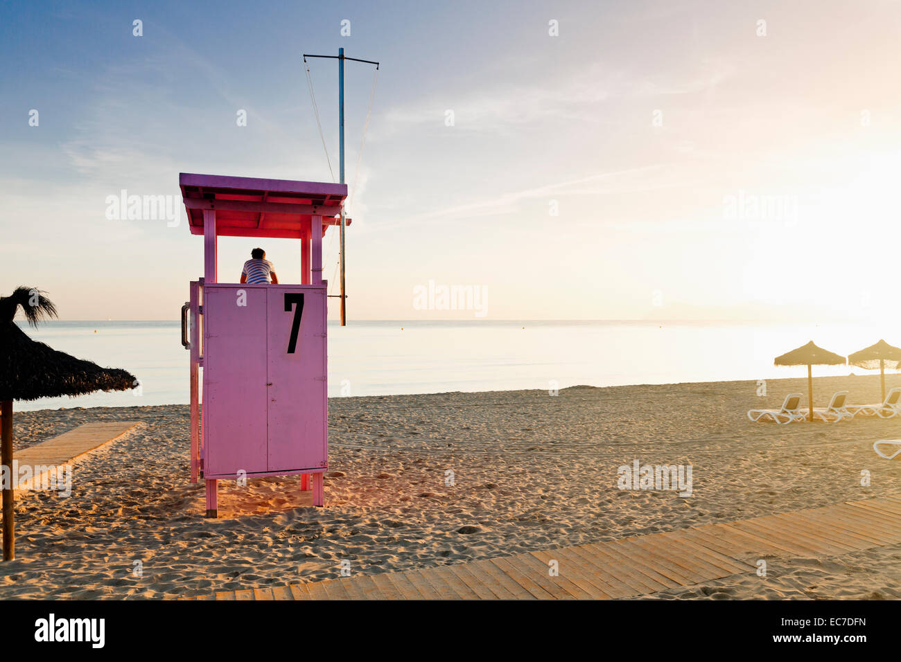 Spain, Balearic Islands, Majorca, one teenage boy standing on a lifeguard stand watching the sea Stock Photo