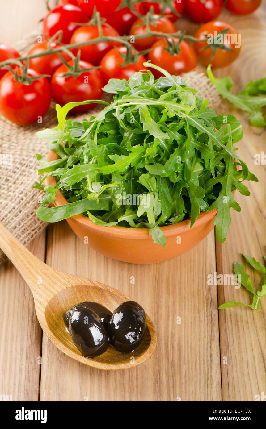 Fresh arugula salad on a wooden table. Selective focus Stock Photo
