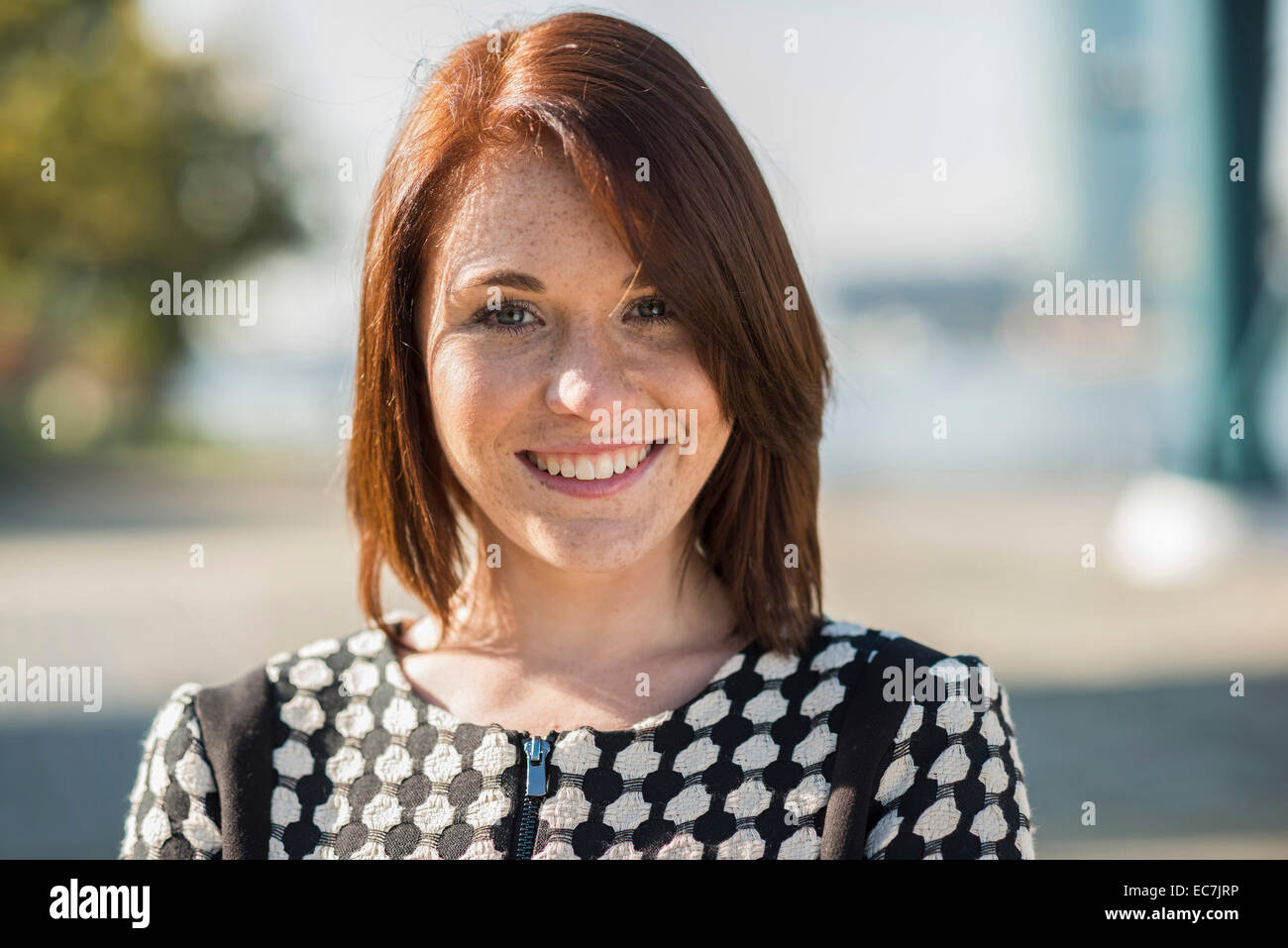 Portrait of smiling brunette young woman outdoors Stock Photo - Alamy