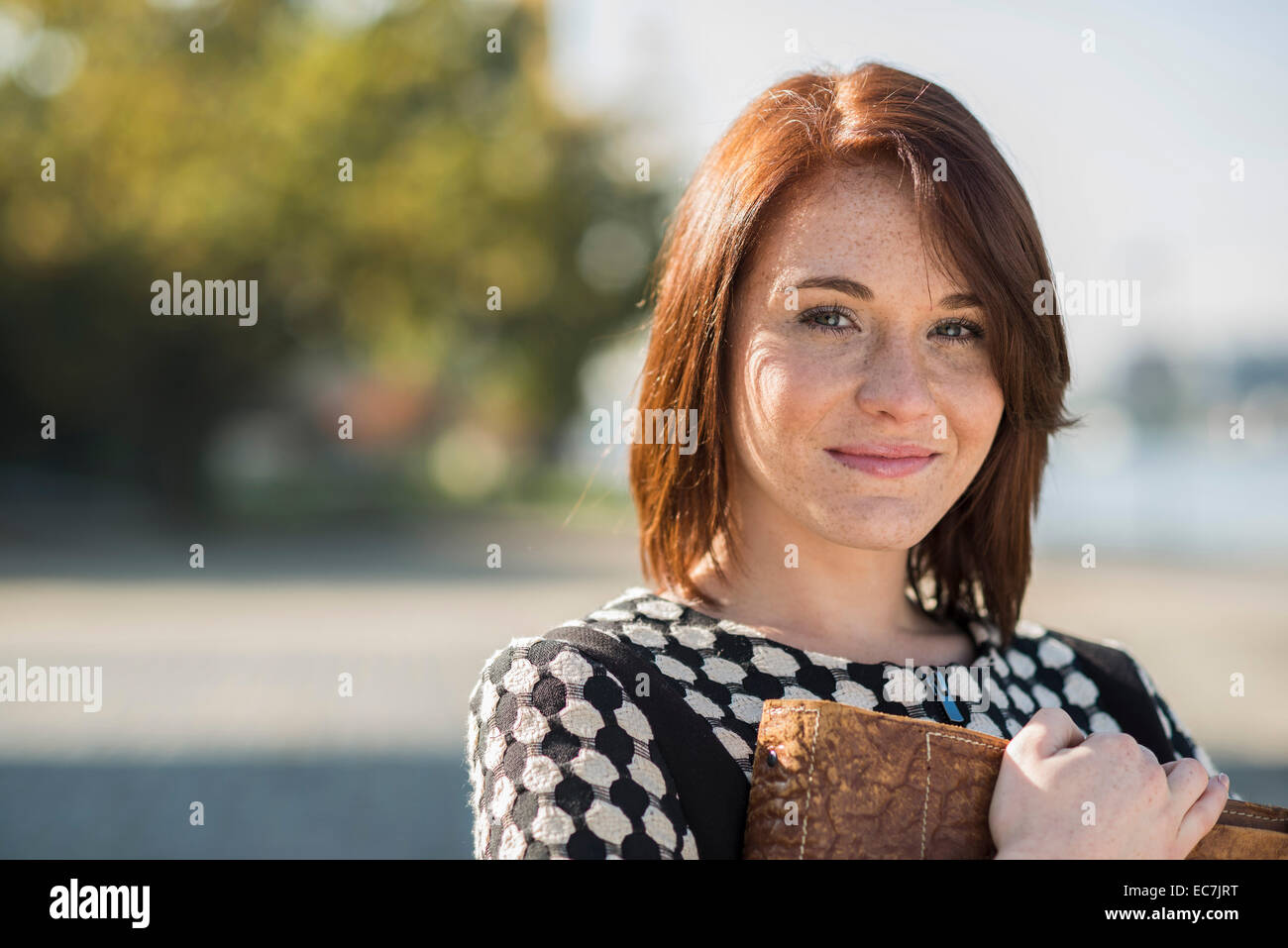 Portrait of smiling brunette young woman outdoors Stock Photo - Alamy