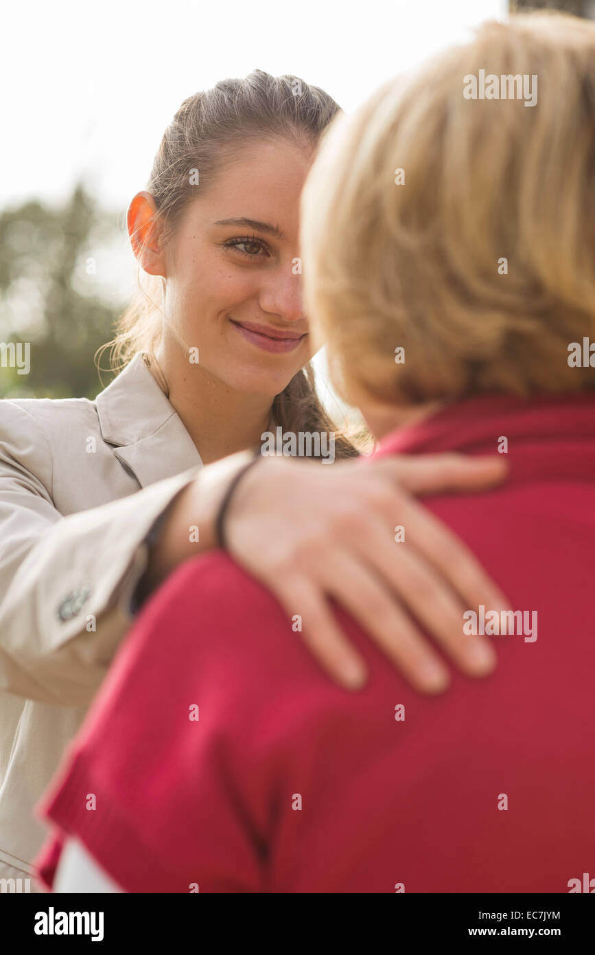 Smiling young woman face to face to her grandmother Stock Photo