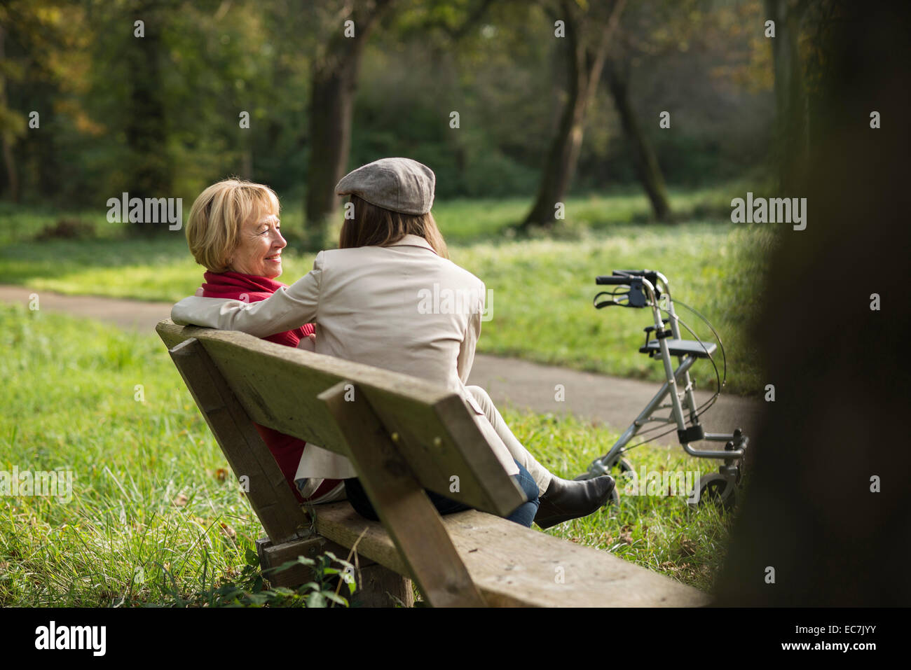Senior woman and granddaughter sitting on a park bench Stock Photo - Alamy