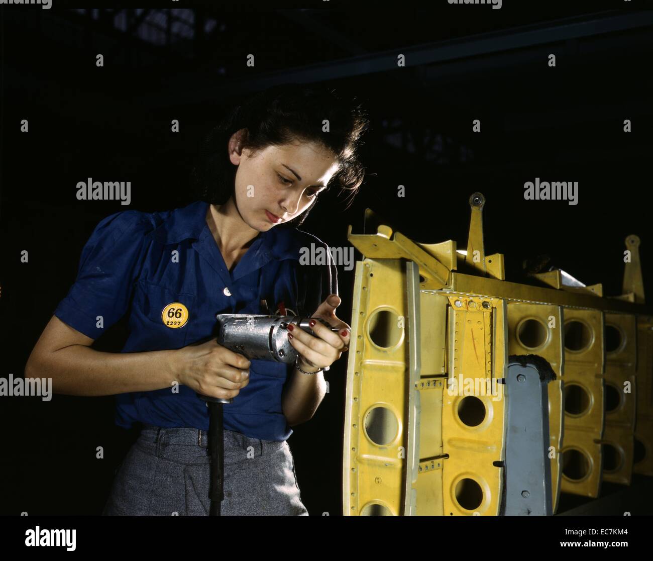 Drilling horizontal stabilizers: operating a hand drill, this woman worker at Vultee-Nashville is shown working on the horizontal stabilizer for a Vultee 'Vengeance' dive bomber, Tennessee. The 'Vengeance' (A-31) was originally designed for the French and was later adopted by the R.A.F. and still later by the U.S. Army Air Forces. It is a single-engine, low-wing plane, carrying a crew of two men and has six machine guns of varying calibers. Stock Photo