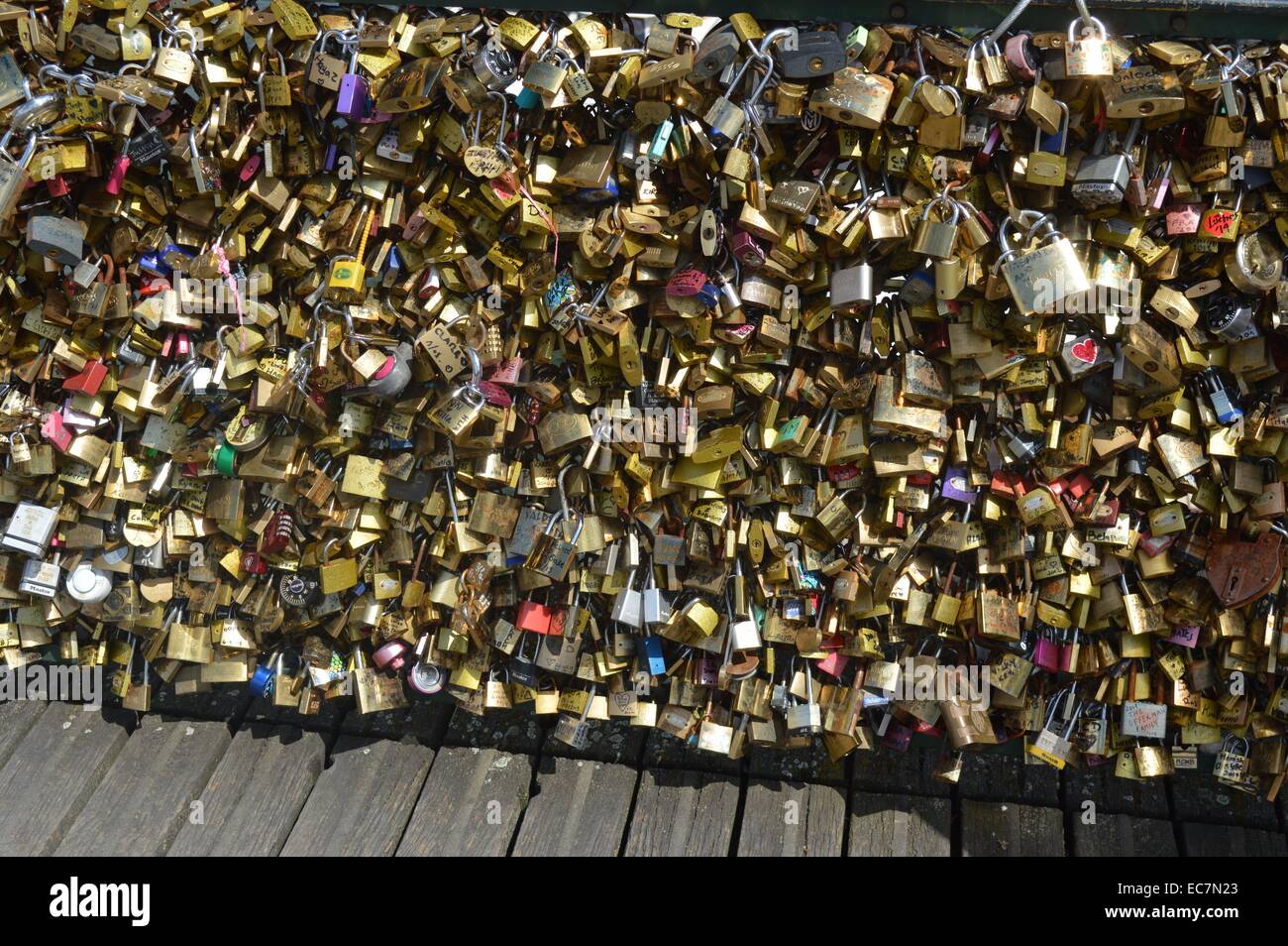 The Pont des Arts or Passerelle des Arts is a pedestrian bridge in Paris which crosses the River Seine. It links the Institut de France and the central square (cour carrée) of the Palais du Louvre. couples have taken to attaching padlocks (love locks) with their first names written or engraved Stock Photo