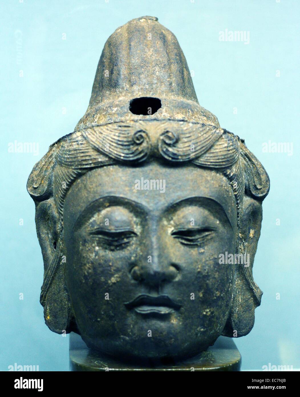 Cast iron head of Buddha, China, Yuan or Ming Dynasty, (circa 1300-1400).  This sculpture demonstrates the height of Chinese cast iron technology. This refined hair, smoothly modelled face and contemplative eyes convey the Buddhist ideal of being compassi Stock Photo