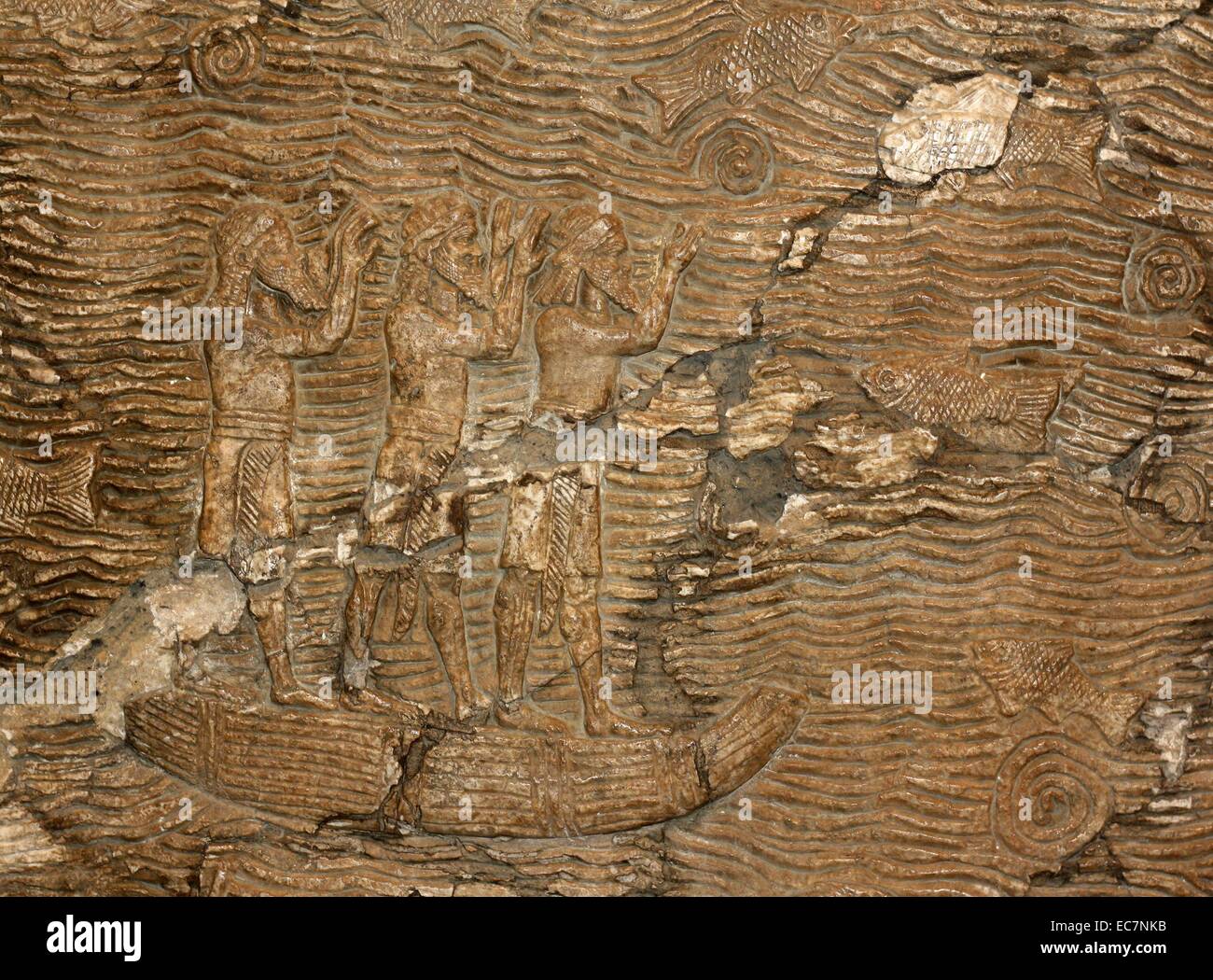 Campaigning in southern Iraq.  Assyrian about 640-620BC.  From Nineveh.  Assyrian soldiers lead prisoners through a landscape of date-palms, with a river beyond.  At the far end heads are counted and the booty piled in front of two clerks  recording the details in a book and on a scroll. Stock Photo