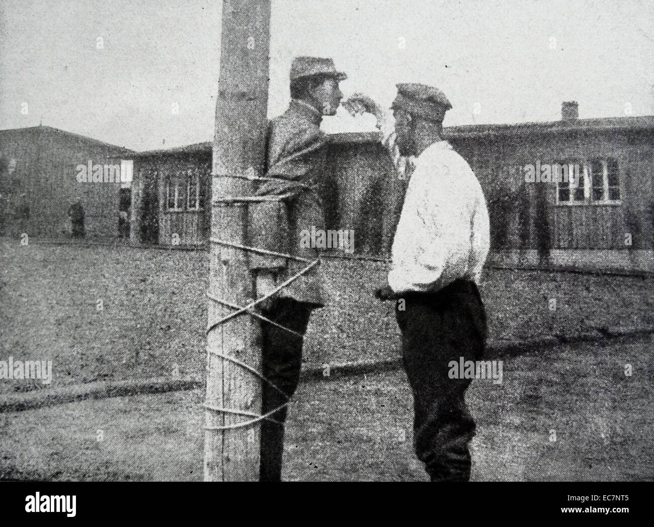A french soldier gives water to a Romanian fellow prisoner of war in a German camp in World War One Stock Photo