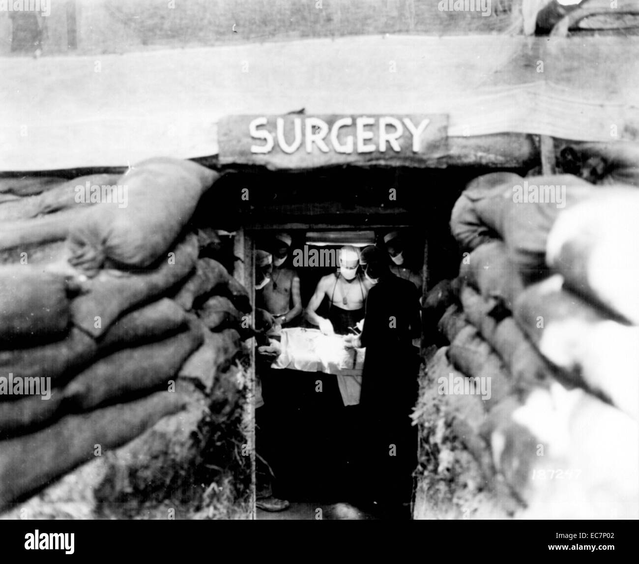 Photograph of a subterrian surgery room. An American doctor operates on a soldier wounded by a Japanese sniper. Dated 1944 Stock Photo