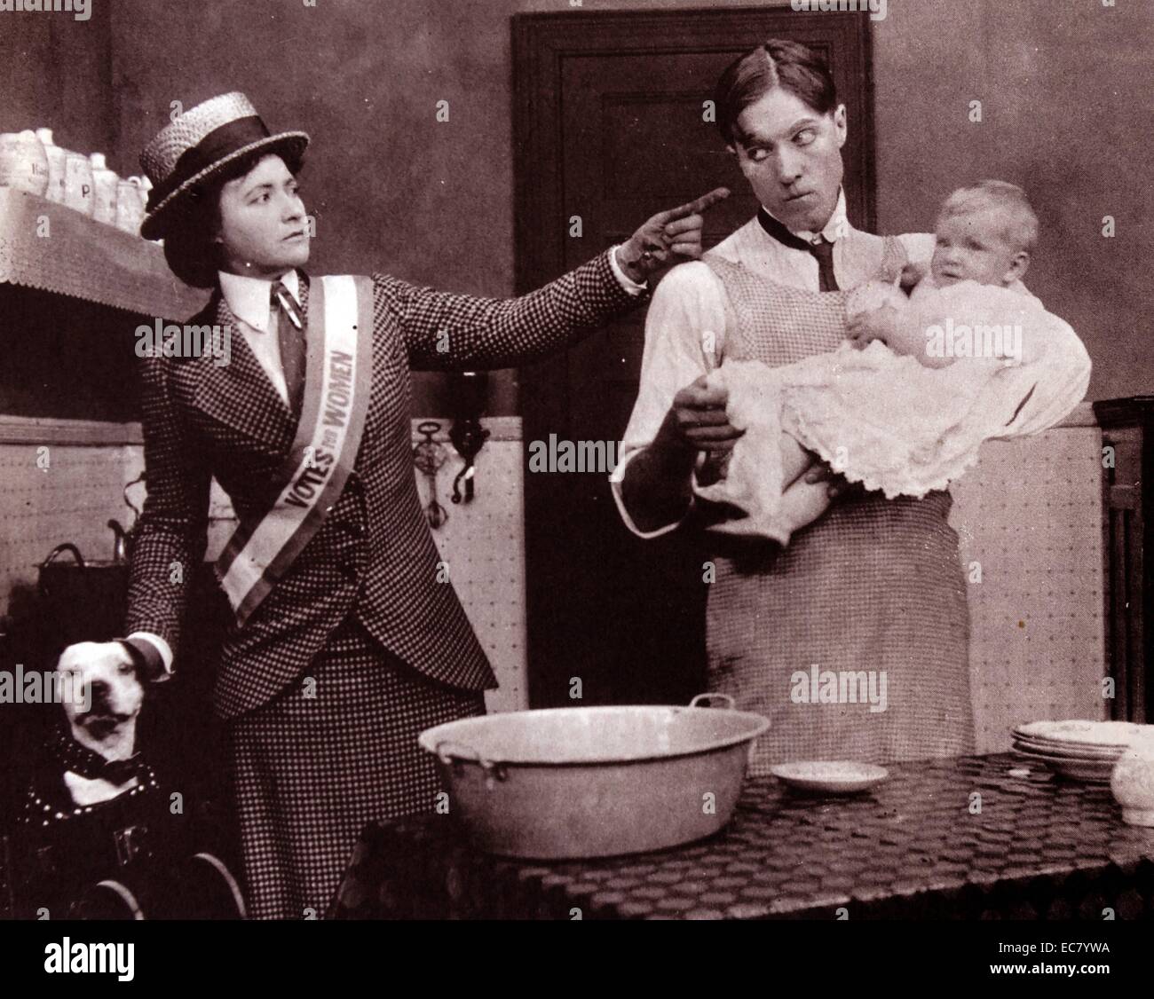 Films of the Nickelodeon Age.  The Suffragette, Edison, c 1912.  Films of the period ridiculed the 'unwomanly woman' who wanted to vote.  Here one of them tells the dog to keep watch on her husband and see that he minds the baby and gets dinner while she is out speech-making. Stock Photo