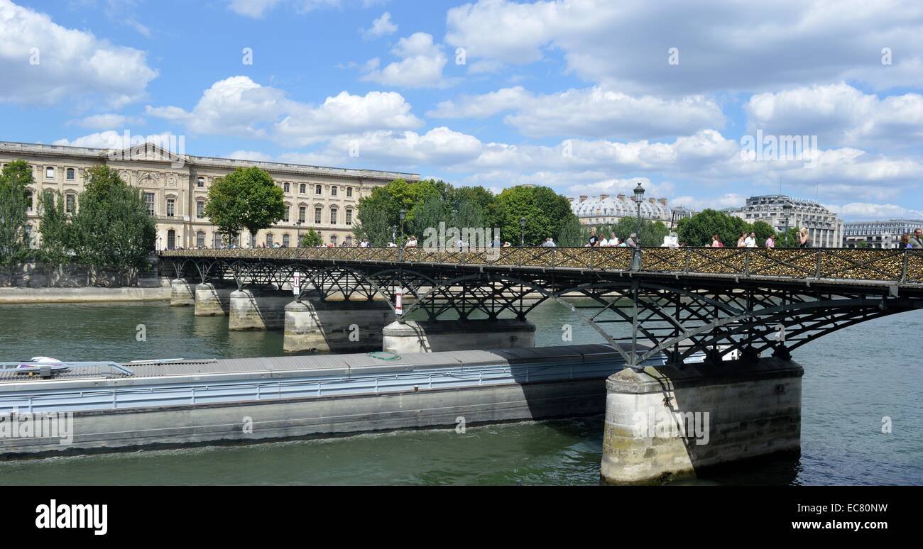 Photograph of the Pont des Arts a pedestrian bridge in Paris which crosses the River Seine. Attached to the fencing of the bridge are Love-Locks, padlocks which sweethearts lock to a bridge, fence, gate, or similar public fixture to symbolize their love. Dated 2014 Stock Photo