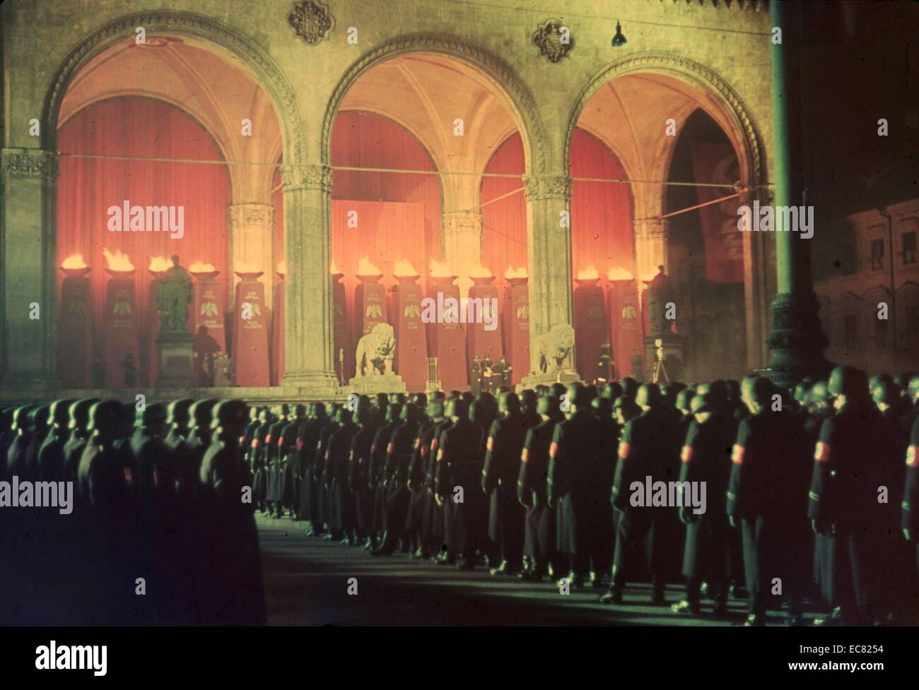 Colour image shows the gathering of the annual midnight swearing-in of Nazi SS troops. Every year the Nazi troops would have to swear an oath of loyalty. The oath read - “I vow to you, Adolf Hitler, as Führer and chancellor of the German Reich, loyalty and bravery. I vow to you and to the leaders that you set for me, absolute allegiance until death. So help me God.” Feldherrnhalle, Munich 1938. Stock Photo