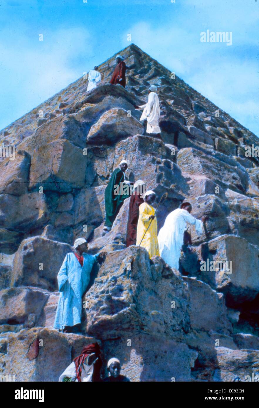 Photograph of Egyptian workers climbing the exterior of the Pyramid of Khafre, Giza. Dated 1925