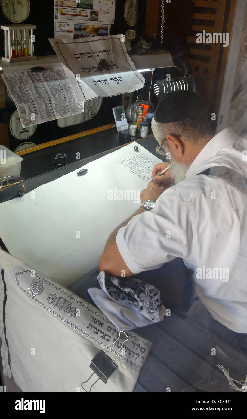 Torah Scribe in Israel carefully writes the old testament by hand on a special parchment or scroll. Stock Photo