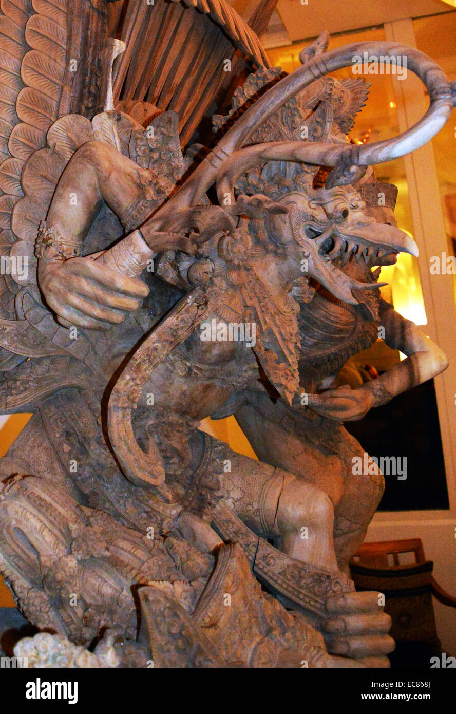 detail of a wooden carved statue of an Indonesian garuda. The Garuda is a large mythical bird; bird-like creature; or humanoid bird that appears in both Hindu and Buddhist mythology. Garuda is the mount (vahana) of the Lord Vishnu. Garuda is the Hindu name for the constellation Aquila. The Brahminy kite and Phoenix are considered to be the contemporary representations of Garuda Stock Photo