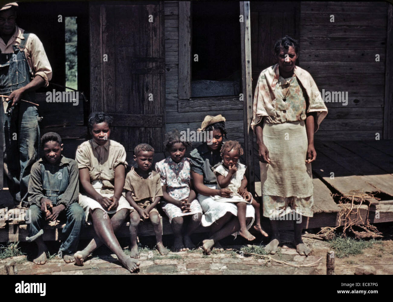 Photograph of a Negro family seated on the porch of a house at the Bayou Bourbeau Plantation, Louisiana. Photographed by Marion Post Wolcott. Dated 1940 Stock Photo