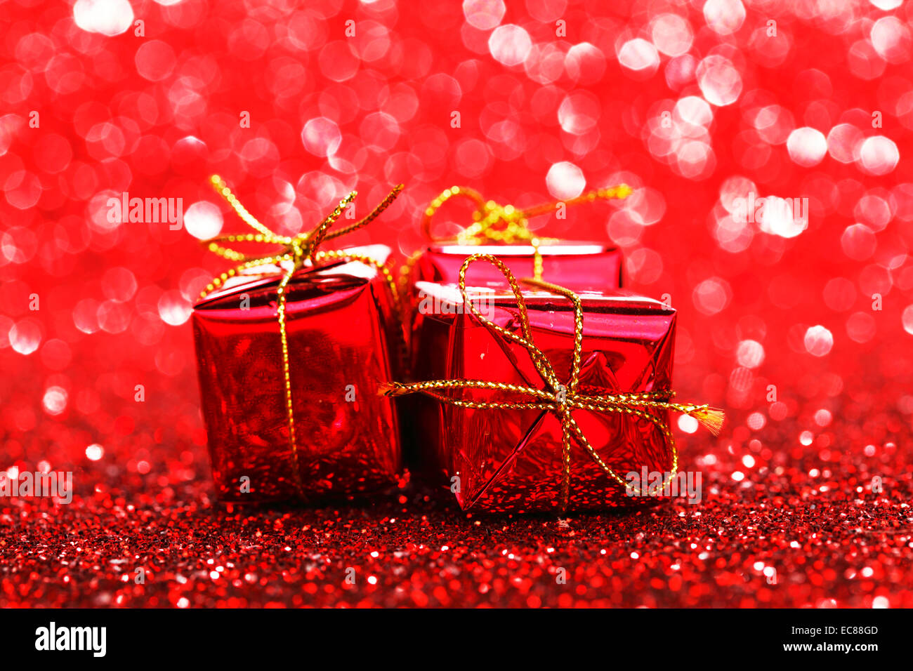 Red Christmas gift boxes on shiny glitter background Stock Photo Alamy