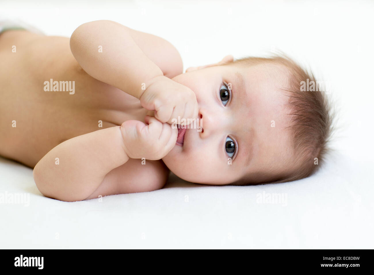 funny baby boy lying on white bed indoor Stock Photo