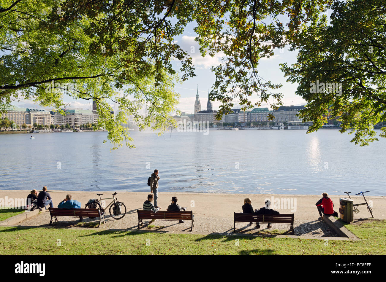 HAMBURG, GERMANY - SEPTEMBER 26: A group of young people seated on benches at the edge of Lake Alster on September 26, 2013, in Stock Photo