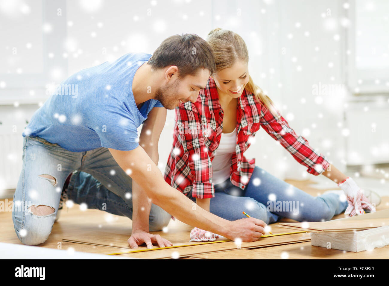 smiling couple measuring wood flooring Stock Photo