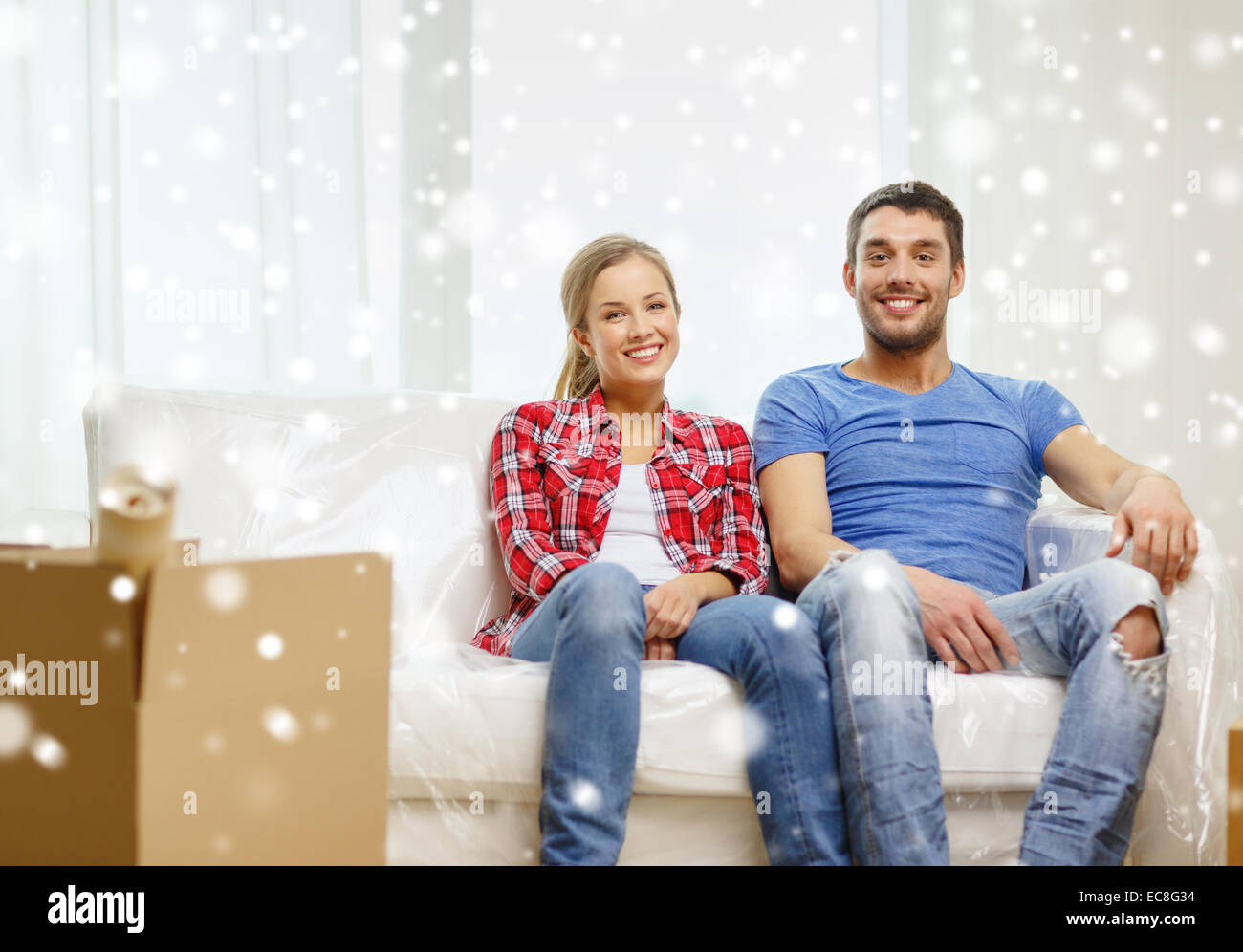 smiling couple relaxing on sofa in new home Stock Photo - Alamy