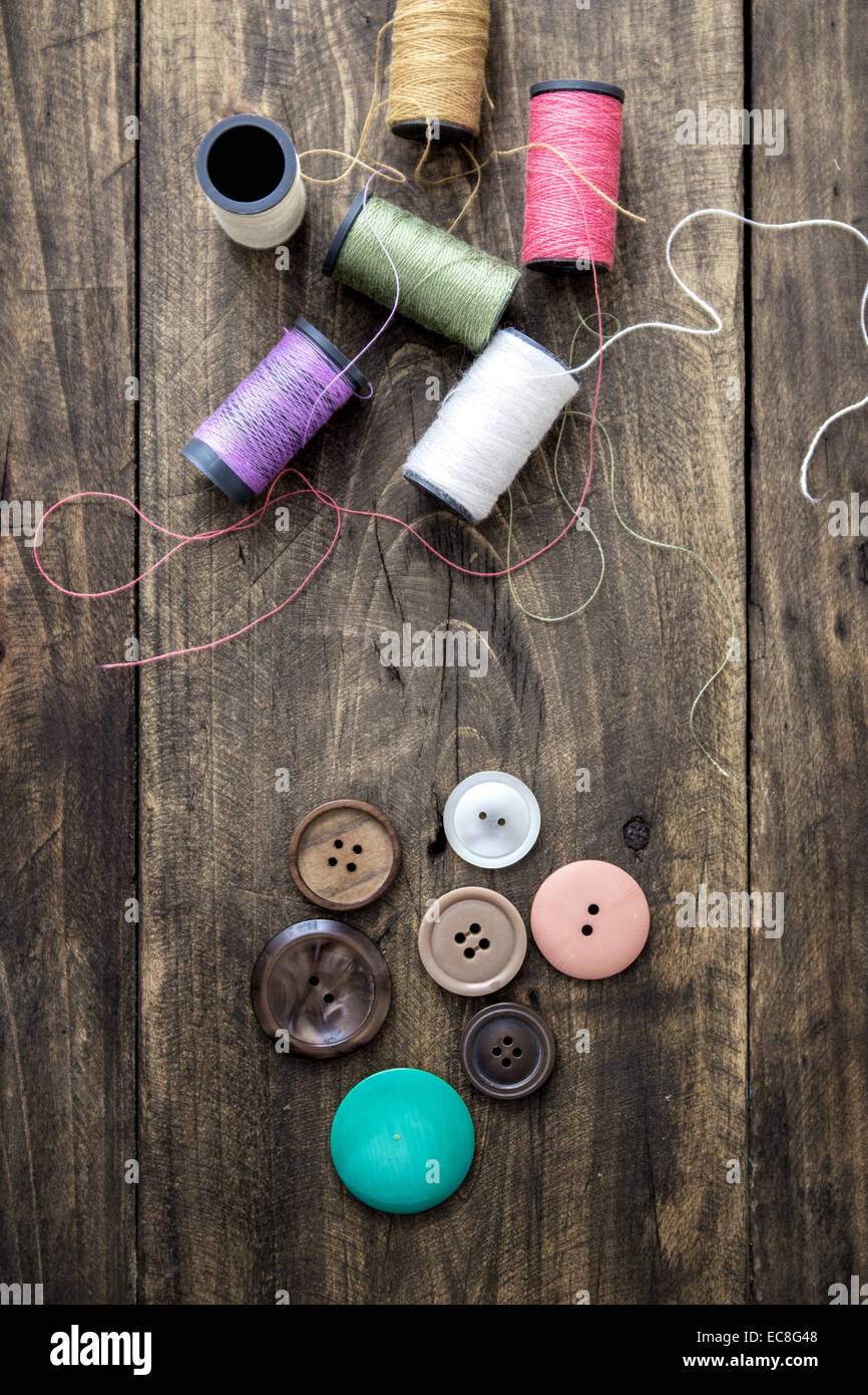 Sewing kit. Scissors and bobbins with thread on the rustic background ...