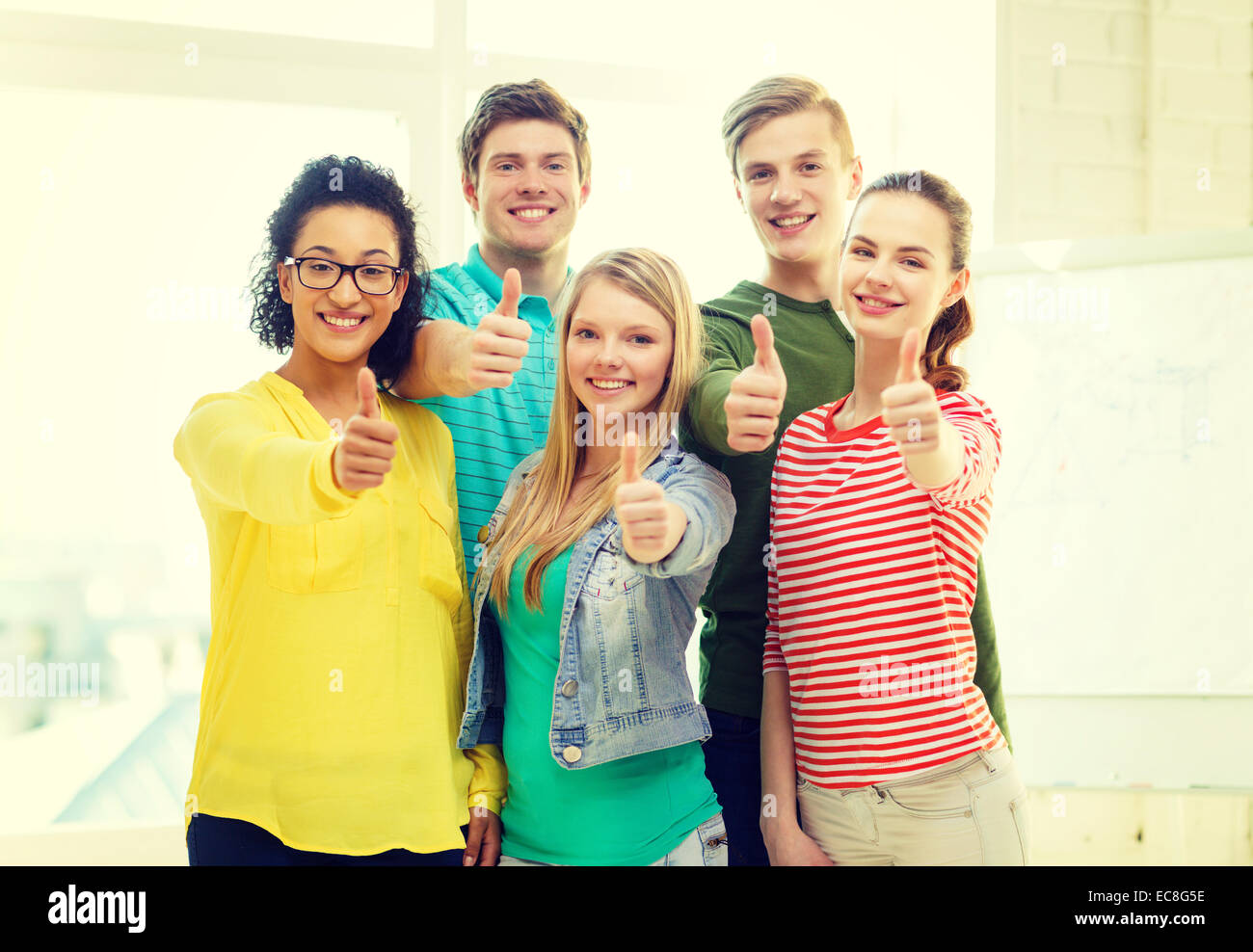 five smiling showing thumbs up at school Stock Photo - Alamy