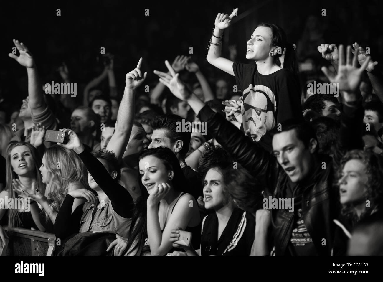 Music fan sitting on shoulders enjoying live concert / festival with hands in the air Stock Photo