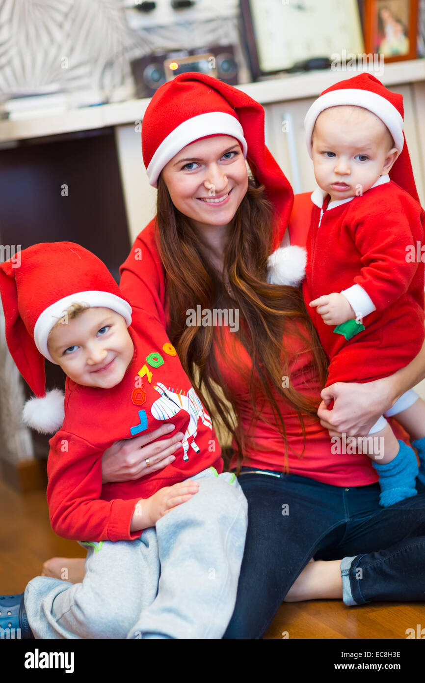 Mother with kids, baby Santas helpers. Merry Christmas and New Year concept Stock Photo