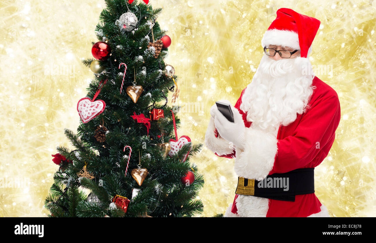 santa claus with smartphone and christmas tree Stock Photo - Alamy