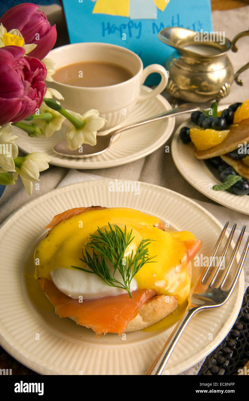 Mother's Day breakfast in bed with eggs benedict and fruit pancakes Stock Photo
