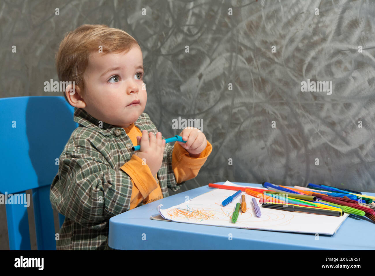 child sitting at a table drawing with colored markers Stock Photo - Alamy