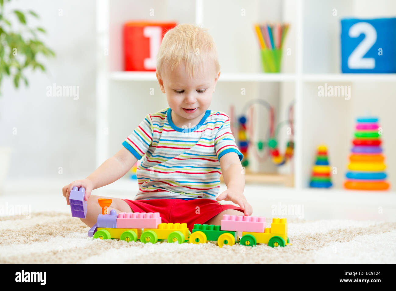 kid boy playing with building blocks at home or kindergarten Stock Photo