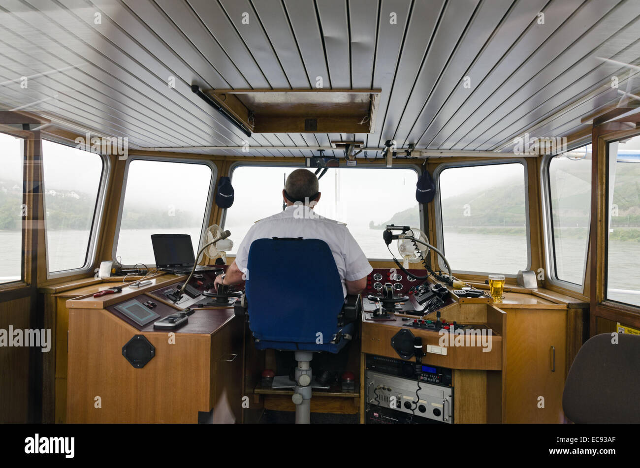 RHINE RIVER, GERMANY - SEPTEMBER 24: helmsman of a passenger ship in control room in September 24, 2013 in Rhine river, Germany. Stock Photo